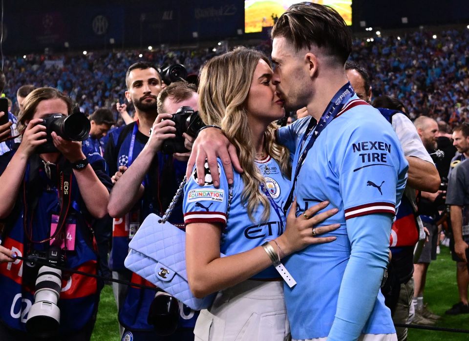 Jack Grealish kisses Sasha Attwood as Man City’s Treble winners joined on pitch by glamorous Wags wearing replica shirts