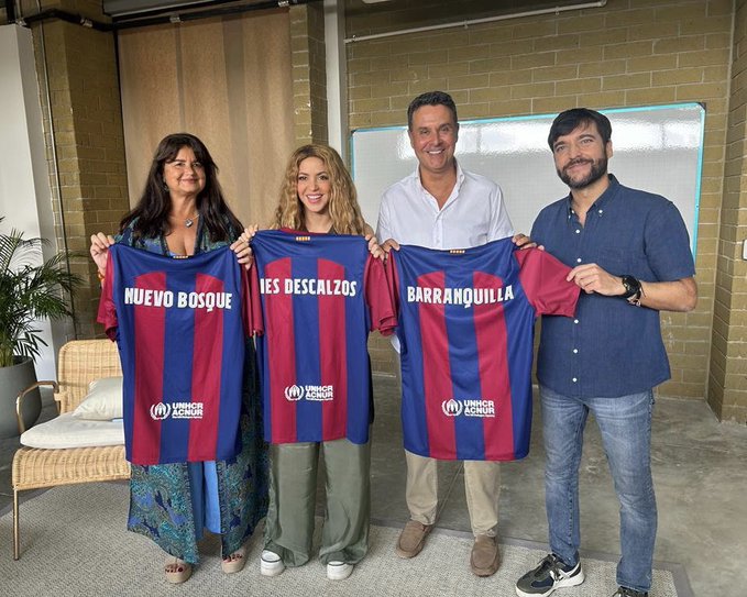 Shakira holds up Barcelona shirt as she poses with staff from Gerard Pique’s former club a year on from split