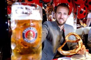 Harry Kane poses wears lederhosen and poses with stein of beer at Oktoberfest after smashing Bundesliga record