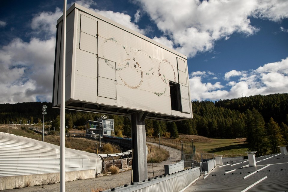 Inside abandoned Olympics track with ghost venue left overgrown with grass and iconic rings torn down