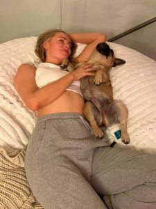 Laura Woods shows off toned abs in crop top and sweatpants as she cuddles up to dog in adorable snap