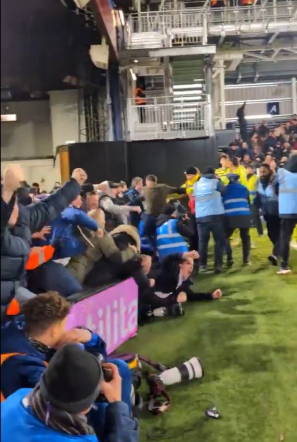 Arsenal fans’ away day turns into chaos with limbs everywhere as man crashes through advertising board and slaps floor