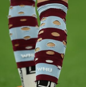 Why do footballers cut holes in their socks?