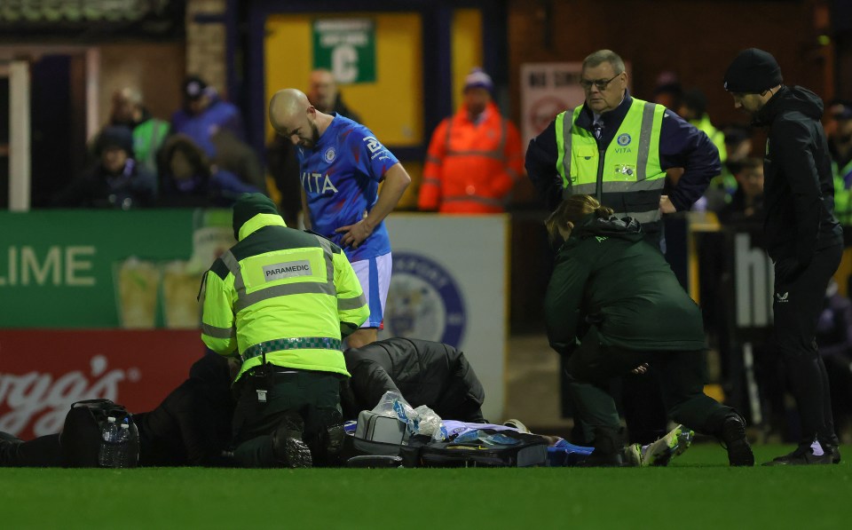 Stockport star put in ambulance after horror clash of heads which saw players frantically wave for medical attention