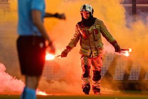 Firefighters forced to enter pitch during Europa League clash with match halted as flares rain down from ultras