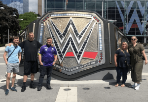 Darts star Luke Littler poses outside WWE World Headquarters with girlfriend Eloise and family on New York trip