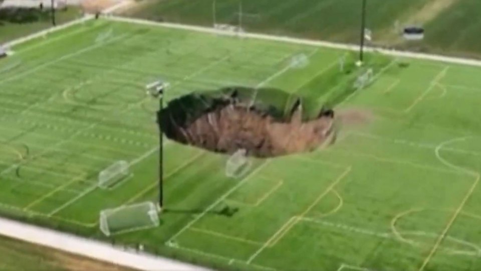 Watch horror moment football pitch collapses as 100-FOOT sinkhole swallows middle of field