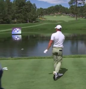 Watch awkward angry Rory McIlroy hurls his driver into a LAKE after bad tee-shot… and has to sheepishly fish it out