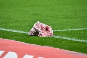 Shocking moment fans throw PIG’S HEAD on to the pitch during bitter derby clash before player kicks it away